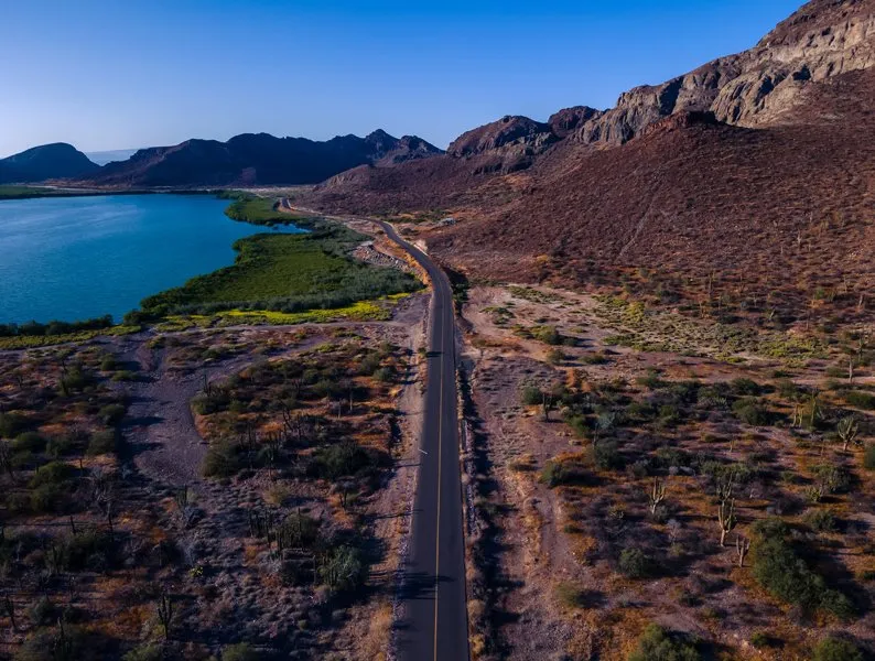 How to Get From La Paz to Playa Balandra in 2026 Coastal road from La Paz to Playa Balandra through desert landscap