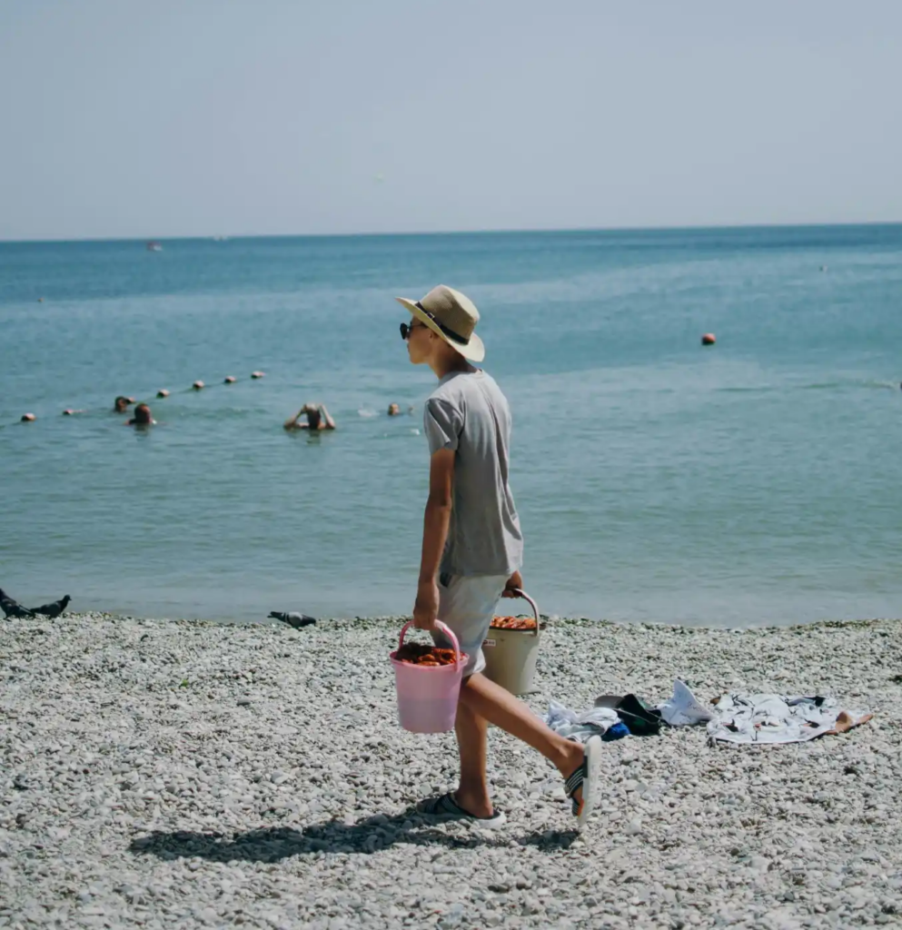 person walking beach buckets