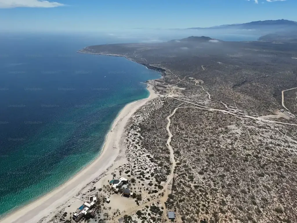 Aerial view of Playa Balandra near La Paz showing the curved shoreline and turquoise coastal water.